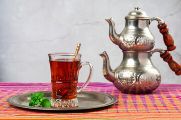 still life with traditional turkish tea in drinking glasses and silver traditional silver tea pot
