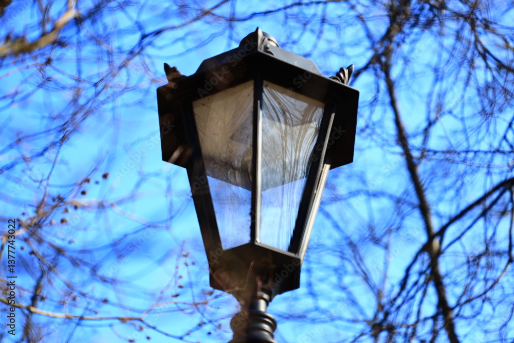 Poster a lamp post with a bird perched on top.