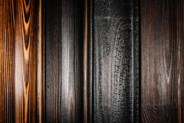 Close-up of various burnt wood planks showing unique textures and tones from charred to polished, emphasizing the natural grain and craftsmanship..