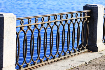 A metal fence near a body of water, suitable for use in a landscape or architectural context.