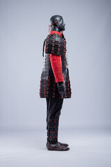 Naklejka premium Full Black and Red Leather Armor Set on Mannequin. Warrior costume with cuirass, padded jacket, pants, and leg protection.