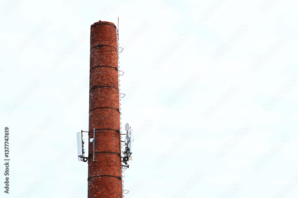 Poster a tall brick chimney with a clock on top, suitable for use in illustrations about old buildings or t