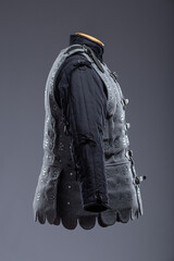 Gray Medieval Brigandine Armor with Leather Straps. This gray brigandine features overlapping metal plates riveted to a fabric base, secured with leather straps.