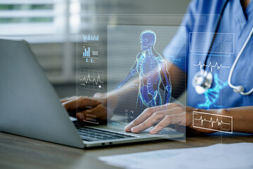 Doctor using a laptop with medical interface displaying a human skeleton.