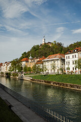 Fototapeta premium Scenic view of Ljubljana, with a river, buildings, and a castle on a hill