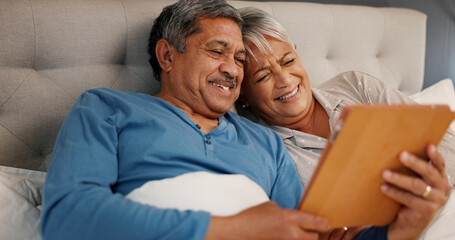 Bedroom, senior couple and happiness with tablet for streaming comedy, reading news and entertainment. Old people, man and woman with laugh for digital joke, funny video or bonding in morning at home