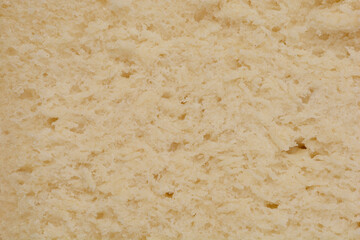 A close-up, macro shot of the interior texture of a bread, showcasing its porous, airy crumb and light color