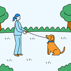 Woman training a dog in a green park  