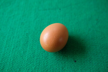 Photo of a chicken egg with a green background