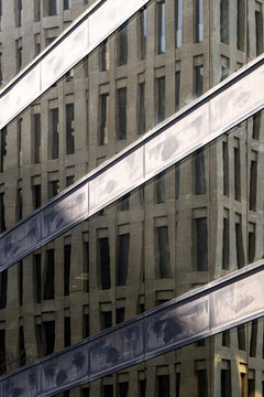 Diagonal metal strips crossing vertical windows on urban facade. Strong graphic style and symmetry for commercial or editorial architecture stock projects.