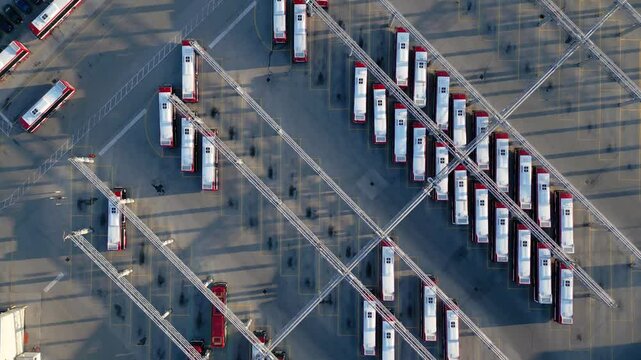 Top down drone view of electric buses and charging stations at public transit centre