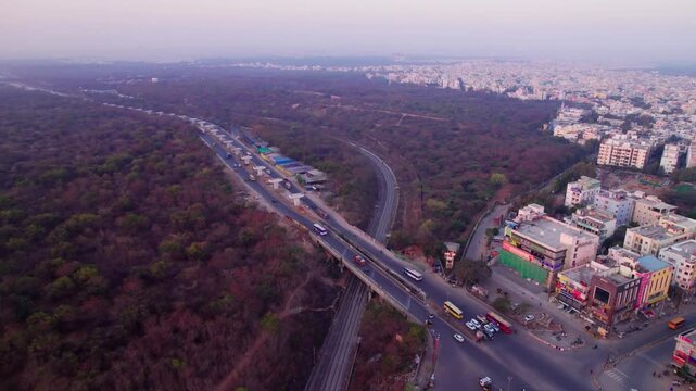 suchitra circle with urban forest and railway track at suchitra, hyderabad, telangana, india. day time, push in, drone shot, 4k.
