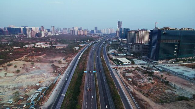 concrete mining with OOR and Glass facade building at Nanakramguda, financial district, Hyderabad, india. day time, pan shot, drone shot, 4k.