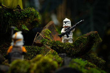 Naklejka premium Depok, Indonesia - April 1, 2025: Lego toys photography, 1st phase clone troopers in dark forest covered with moss, with bokeh background