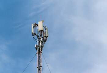 The top of a tall mast with mobile cellular antennas