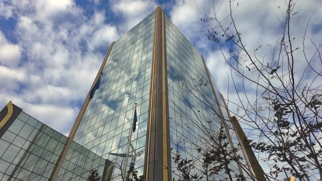 Glass facade of OLAF headquarters building in Brussels under cloudy sky