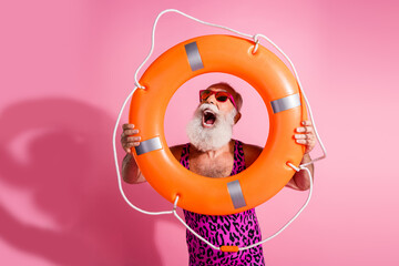 Photo of emotional shocm old man hold look orange lifebuoy wear leopard print swimsuit isolated pink color background