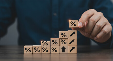 Hand Stacking Wooden Blocks with Percentage Sign and Arrow Up Symbolizing Growth in Dark Blue Shirt