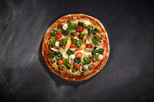 Pizza Green Garden mit Brokkoli, Spinat, Kirschtomaten, Champignons und Mozzarella &ndash; bunt und vegetarisch