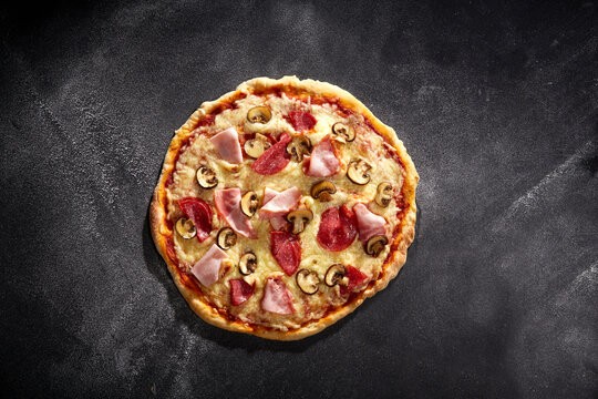 Pizza Lucia mit Salami, Kochschinken, Champignons und K&auml;se &ndash; rustikal serviert