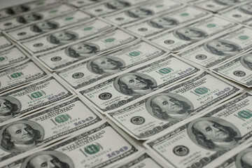 One hundred dollar bills neatly laid out diagonally