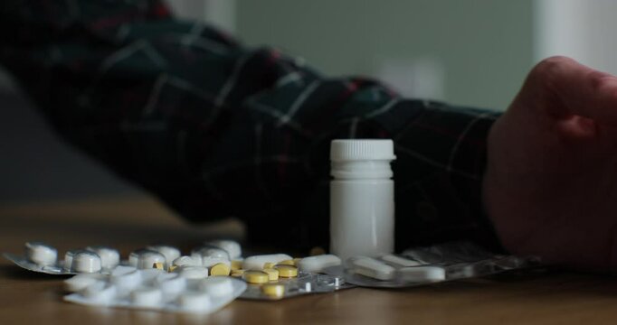 A man hand throws away medicine, refusing it. Pharmaceutical, medical capsules, tablets.