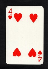 A vintage playing card in the suit of hearts isolated on a black background.