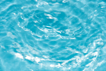 Obraz premium Blue water with ripples on the surface. Defocus blurred transparent blue colored clear calm water surface texture with splashes and bubbles. Water waves with shining pattern texture background.