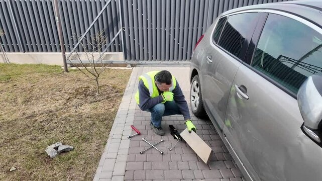 A guy changes tire on street to summer tire in nature