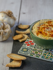 Beautiful bowl of hummus, traditional Middle Eastern vegetarian dish based on chickpeas and seasoned with olive oil and paprika