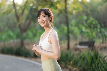 Asian woman outdoor workout, healthy and active lifestyle concept. She smiles confidently in park,...