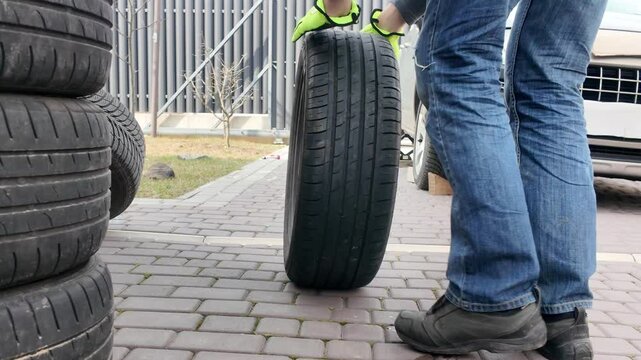 A guy changes tire on street to summer tire in nature