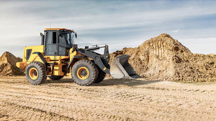 Construction site with a loader moving dirt during daylight hour