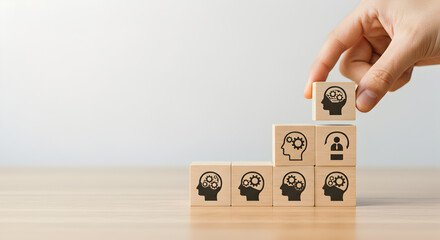 Hand Stacking Wooden Blocks with Head Icons Representing Business Growth Strategy and Teamwork on Light Background