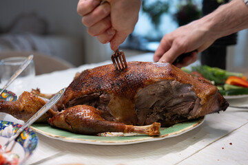 Chef carving roasted duck on serving platter for festive holiday meal