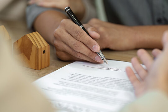 Client signing a real estate agreement, showcasing the commitment to a property deal.