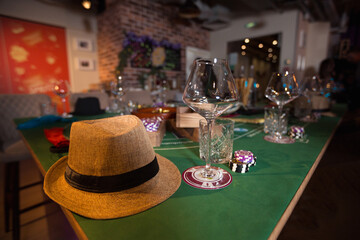 Casino party: poker chips, wine glasses, and a hat on a gaming table in an atmosphere of luxury and excitement