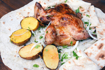 Fried chicken with potatoes. Grilled chicken with potatoes and herbs on a white plate. Roast chicken with potato and onion on pita bread. Restaurant food