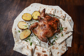 Fried chicken with potatoes. Grilled chicken with potatoes and herbs on a white plate. Roast chicken with potato and onion on pita bread. Restaurant food