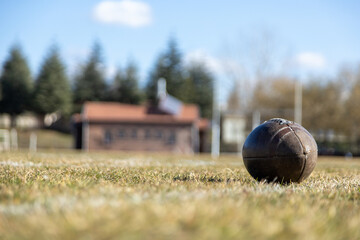 american football ball, worn american football ball and football field, grass and white lines, leather ball