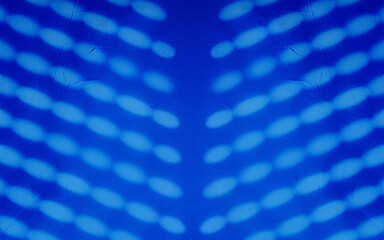 Blurred light spots, shadows from the blinds on the concrete wal