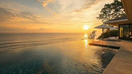 A sophisticated luxury villa with an infinity pool overlooking the calm ocean, with the sun casting a golden glow over the water.