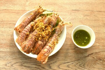 fried mantis shrimp with chop crispy garlic on plate dipping Thai spicy seafood sauce 