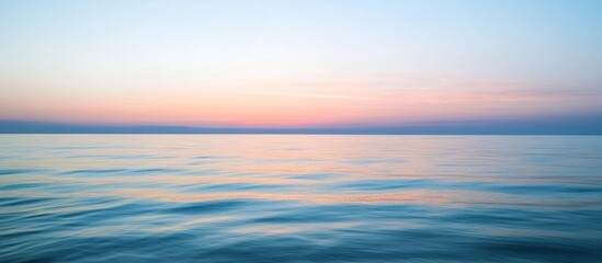 Fototapeta premium Peaceful oceanic waters reflecting colors from the pastel sunset above