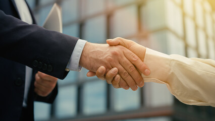 B2b concept working relationship partnership handshake two business people in city woman man meeting shaking hands unity cooperation deal job recruit opportunity closeup offer negotiation welcome