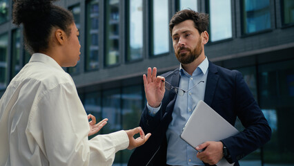 Angry African American woman businesswoman female leader CEO boss irritated talk to Caucasian man...