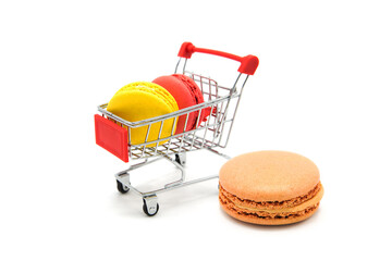 Shopping supermarket cart with colorful varied assortment macarons cookies isolated on a white...