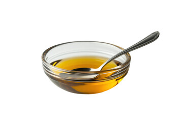 Transparent glass bowl with amber liquid and metal spoon on black background, cut out