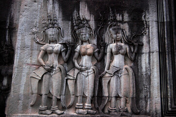 Naklejka premium Sculpture carving figure apsaras or apsara angel deity female spirit of clouds and waters elegant and superb art of dancing in Hindu and Buddhist culture on wall of Angkor wat at Siem Reap, Cambodia