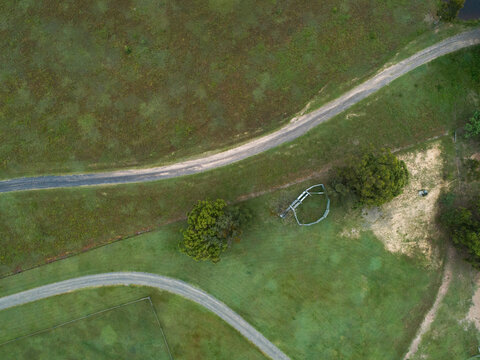 aerial view of two driveways in rural paddock with stockyard and fences